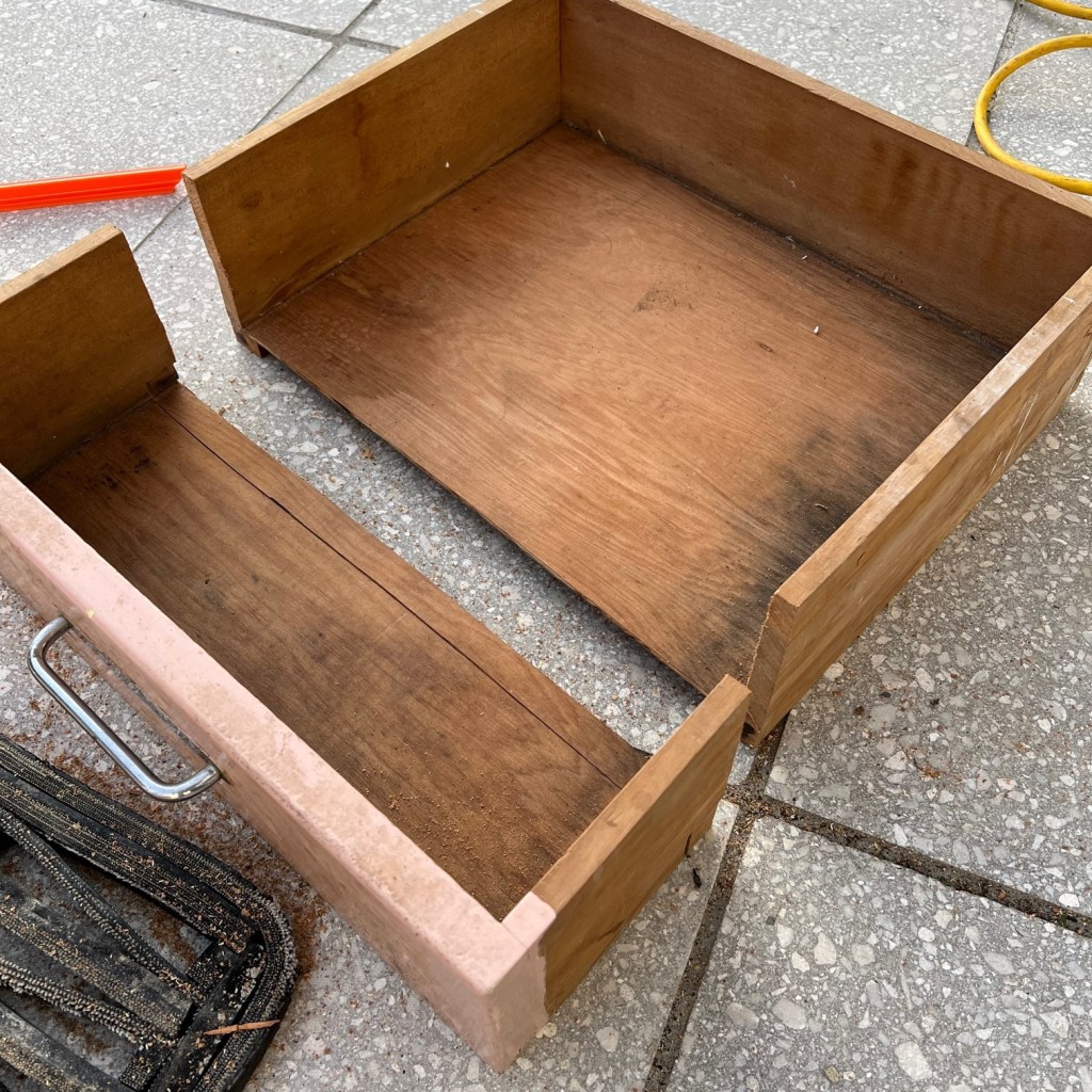 An old kitchen drawer with the front sawn off, leaving a box shape perfect for the base of a fly tying station