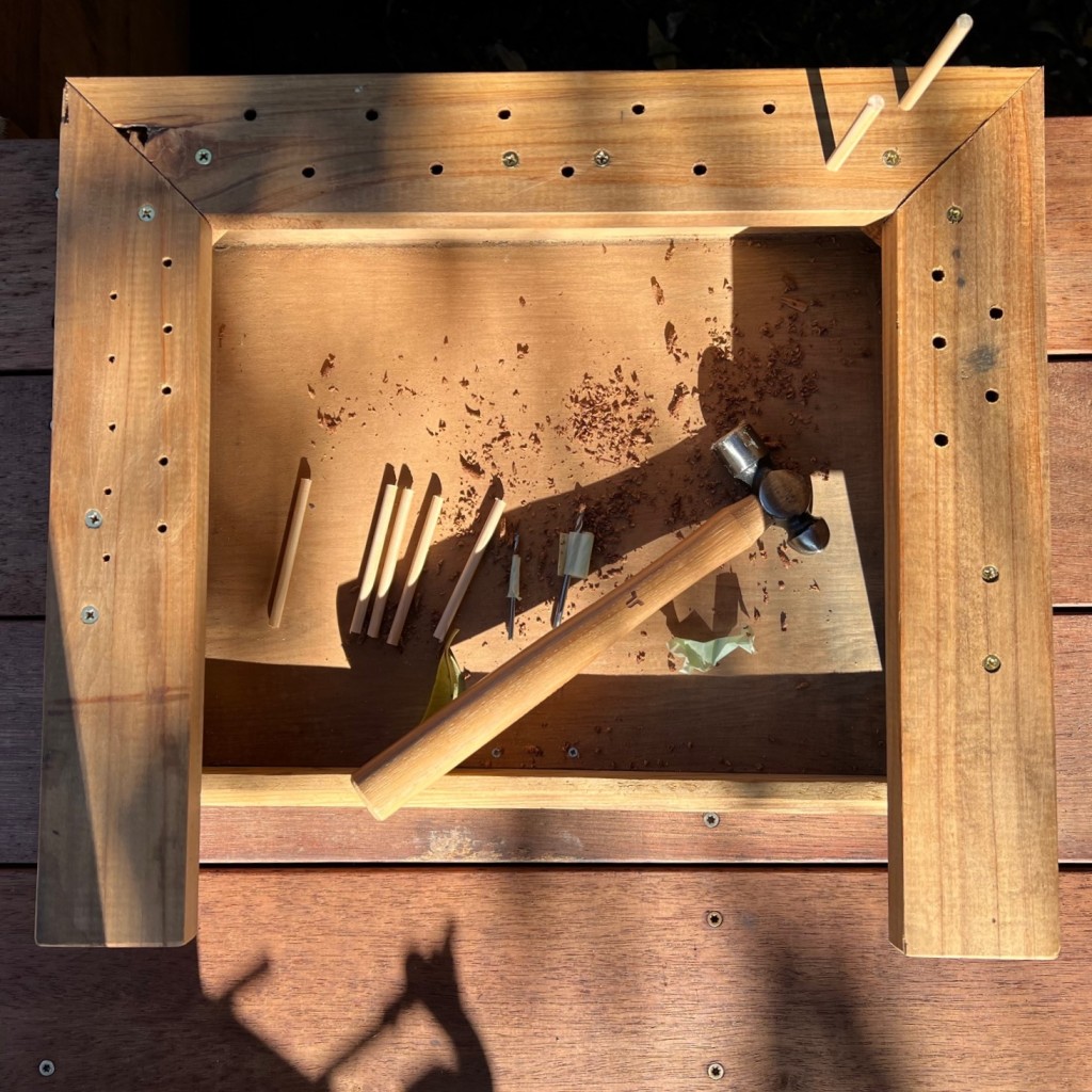 The fly tying station in progress, with holds drilled for fly tying tools and thread bobbins