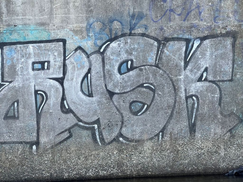 Graffiti on a river bridge pylon, Pakuratahi River, Upper Hutt, New Zealand
