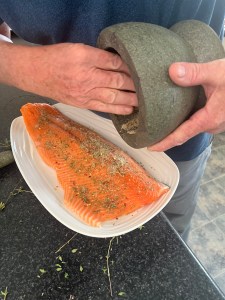 Spices are poured onto a fillet of salmon