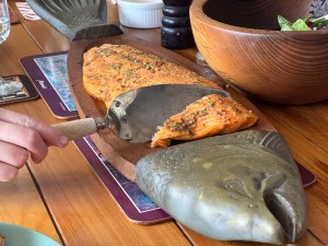The cooked salmon is served of a fish-shaped serving platter